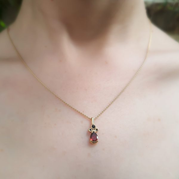 Hayley necklace 14k gold Pendant with pear shaped garnet stone and 3 black diamonds and a gold necklace